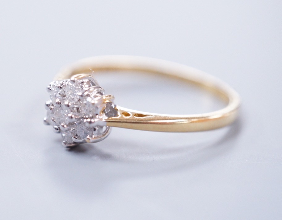 A modern 18ct gold and seven stone diamond set flower head cluster ring, size P, gross weight 2.4 grams